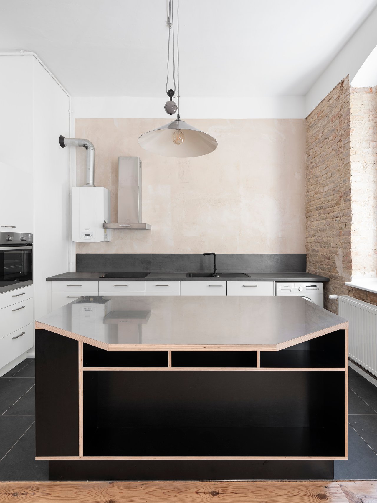 Moderne Kücheninsel mit Arbeitsplatte und integrierter Spüle in einem hellen, minimalistischen Küchenambiente