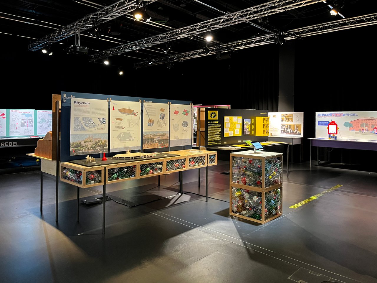 Ausstellung in einem Museum oder Konferenzzentrum mit Informationsständen und einem interaktiven Element zu einem Thema wie 'Rhyclaim'
