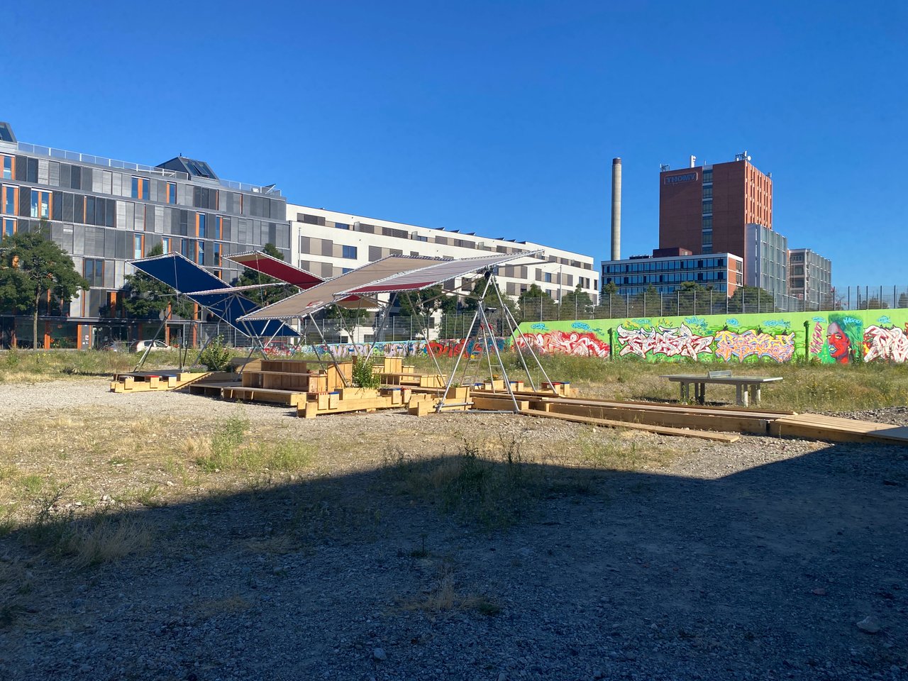 Moderne Architektur und Freifläche mit temporären Sitzgelegenheiten an einem sonnigen Tag