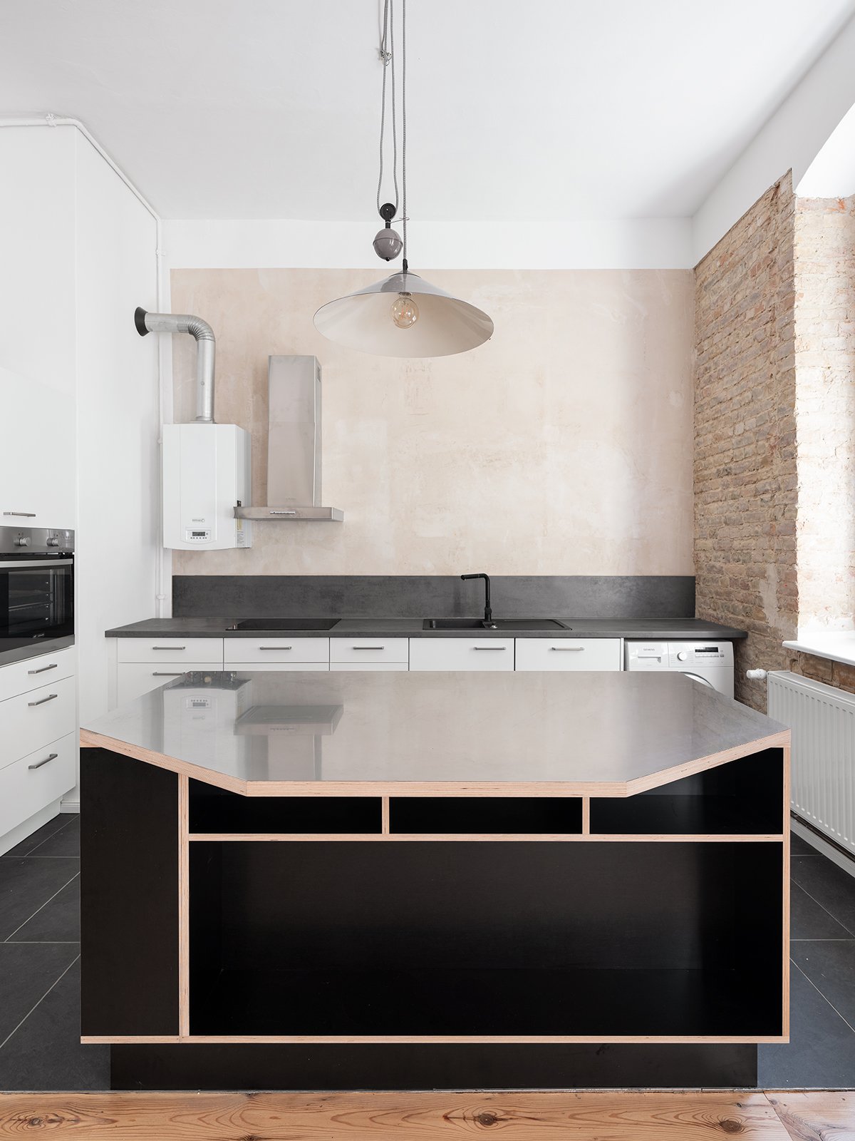 Moderne Kücheninsel mit Arbeitsplatte und integriertem Spülbereich in einem hellen, minimalistischen Küchenambiente